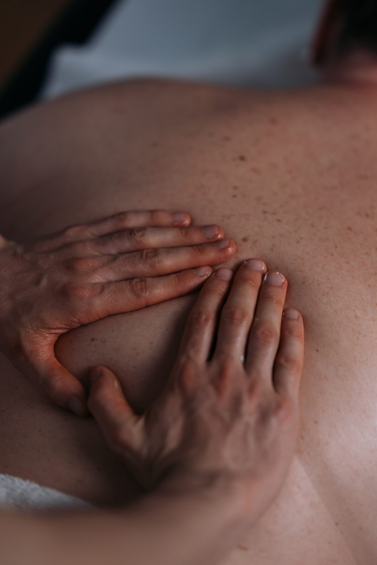 Mãos do terapeuta em pressão profunda nas costas