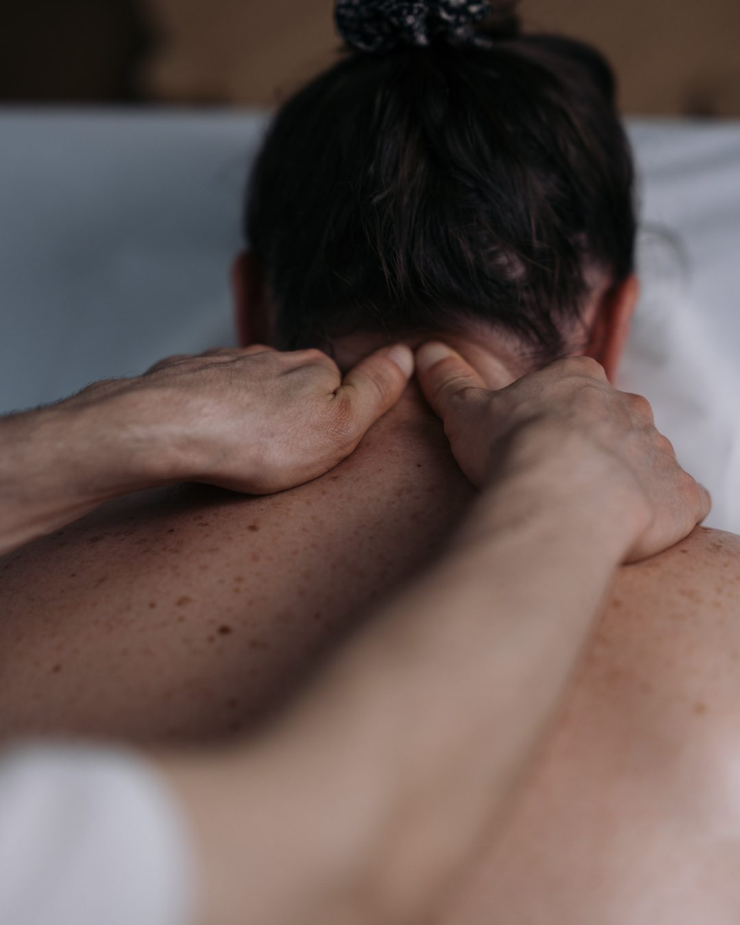 Mãos do terapeuta na nuca de uma paciente